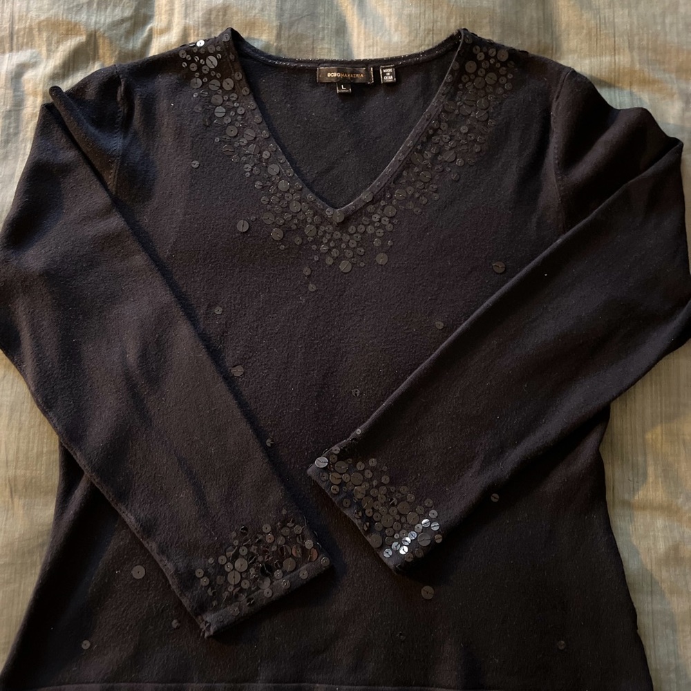 Long sleeved knit top with sequins scattered around the front, sleeves and neck.